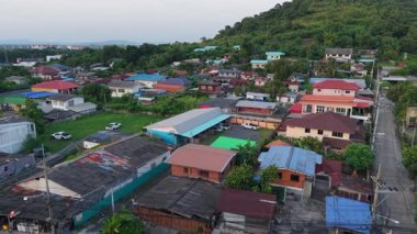 Tayland 'ın kırsal kesiminde ağaçlar ve yol arasında inşa edilmiş küçük evler - 4K Yatay