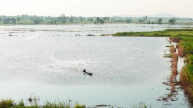 Geleneksel bir balıkçı Asya 'daki sel basmış düzlüklerde geziniyor - 4K Yatay