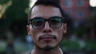 Büyük gözlüklü ve kameraya bakan küçük bıyıklı Latin bir çocuğun yüzünü yakından çek. 4K Yatay