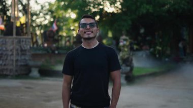 Koyu tenli Latin çocuk Tayland 'da kameraya doğru giderken gülümsüyor. 4K Yatay