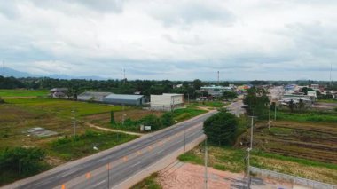 Kırsal bir yolda giden arabalar küçük bir Asya köyüne gidiyor - 4K Yatay