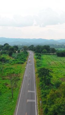 Taşıtlar kaldırımlı bir yolda, kırsal bir alanda, FullHD dikey