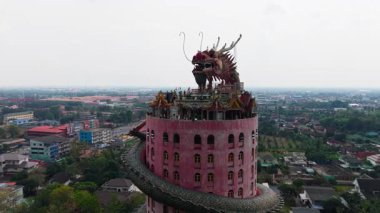 Bir ejderha Wat Samhran 'daki pembe silindirik kule etrafında dönüyor Bangkok yakınlarındaki bir Budist tapınağı - 4K Yatay