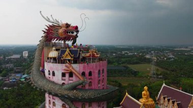 Wat Samphran Bangkok yakınlarındaki bir Budist tapınağında dev bir ejderhası olan çarpıcı pembe silindirik bir bina bulunuyor - 4K Yatay