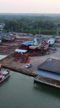 Balıkçı tekneleri bakımlı ve onarımlı tropikal bir ormanın yakınındaki rıhtıma yanaştı.