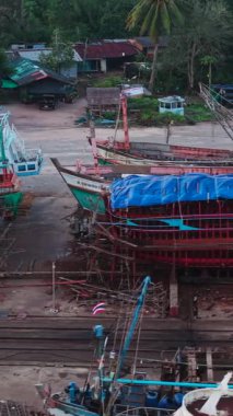 Dronesold 'un köhne balıkçı tekneleri kirli bir tersanede sıralanmış, FullHD Dikey