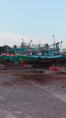 Çok sayıda balıkçı teknesi onarılmayı bekleyen bir tersanede destek bekliyor.