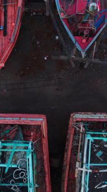 Bir gemi mezarlığındaki terk edilmiş ve mahvolmuş balıkçı teknelerinin insansız hava aracı görüntüsü FullHD Dikey
