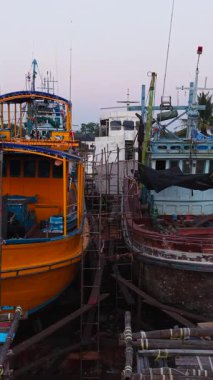 Tersanedeki bambu yapılarda bakım altındaki balıkçı tekneleri - FullHD Dikey