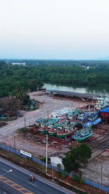 Balıkçı tekneleri Tayland 'da bir otoyolun yakınındaki bir tersanede karada dinleniyor.