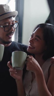 Genç Heteroseksüel bir çift dairelerinde kahvenin tadını çıkarıyorlar.