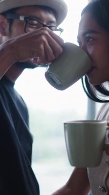 Mutlu genç Asyalı heteroseksüel çift, FullHD dikey kahve içerken bir anı paylaşıyor.