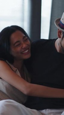 Asyalı çift rahat bir kanepede kucaklaşmayı seviyor.