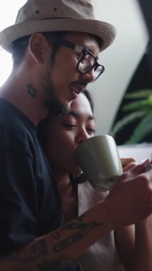 Asyalı çift, FullHD dikey kahve içerken bir yakınlık anını paylaşıyor.