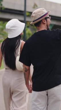 Parkta el ele tutuşan iki Asyalı turist FullHD Dikey