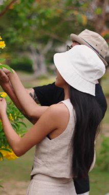 Genç Asyalı Çift Heteroseksüel Romantik Kokulu Sarı Çiçekler Bir Parkta - FullHD Dikey