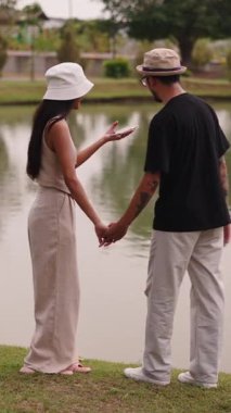 Genç Asyalı turistler fotoğraf çekiyor ve FullHD dikey bir göl manzarasının keyfini çıkarıyorlar.