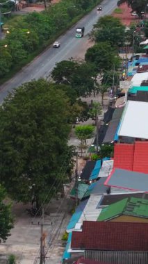 Tayland 'ın kırsal kesimindeki kluai khai pazarında düz bir yolda giden arabalar ve kamyonlar