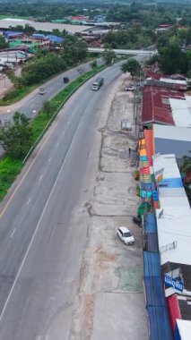 Otoyolda giden araba ve kamyonlar kluai khai pazarındaki küçük bir köyden geçiyor Tayland - FullHD Dikey
