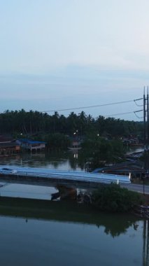 Gün batımında sakin nehir topluluğu ve günbatımında geleneksel evler - FullHD Dikey