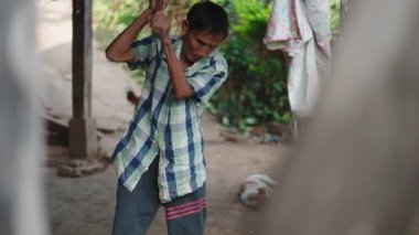 Lahu kabilesinden yaşlı bir çiftçi Tayland 'da ev yapımı baltayla odun kesiyor - 4K Yatay