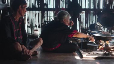 Lahu kabilesinin evinde geleneksel yemek pişiren yaşlı kadın - 4K Yatay