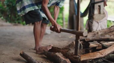 Kırsal bir alanda çıplak ayaklı çiftçi yakacak odun kesiyor - 4K Yatay