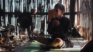 Eski Lahu geleneksel giysiler içinde ateşin karşısında bağdaş kurarak oturuyor - 4K Yatay