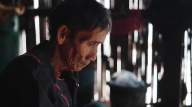 Tayland 'da Lahu kabilesinin evinde yemek pişirirken Asyalı yaşlıların yüzüne yakın çekim - 4K Yatay