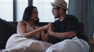 Genç Asyalı romantik çift rahat bir koltukta birlikte şefkatli anların tadını çıkarıyor - 4K Yatay