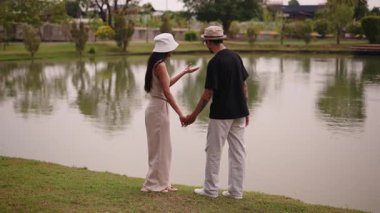 Genç Asyalı turistler fotoğraf çekiyor ve göl manzarasının tadını çıkarıyor - 4K Yatay