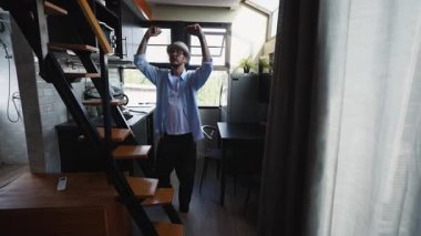 Mutlu çıplak ayaklı Asyalı çocuk modern ve zarif mutfağında dans ediyor - 4K Yatay