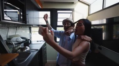 Yeni modern evlerinin mutfağında selfie çeken genç çift - 4K Yatay