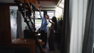 Genç çıplak ayaklı Asyalı çift dans ediyor ve kendilerini akıllı bir telefonla kaydederken eğleniyorlar - 4K Yatay