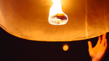 Fener festivali gecesi yükselmeden önce kablolarla tutulan kağıt fener ve ateş çemberi - 4K Yatay