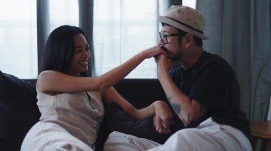 Genç Asyalı Adam Genç Ortaklarını Kanepede Elini Öpüyor - 4K Yatay