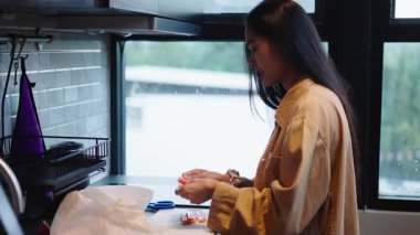 Süslü bir mutfakta yemek yapmak için suşi çubukları hazırlayan genç bir kadın - 4K Yatay