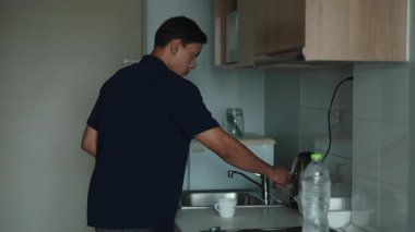 Asyalı Adam, Samrtphone 'unun yanındaki Minimalist Mutfakta Anında Kahve Yapıyor - 4K Yatay