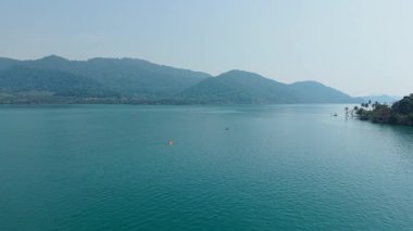 Resimli dağ manzarasının ortasındaki sakin bir gölde kano - 4K Yatay