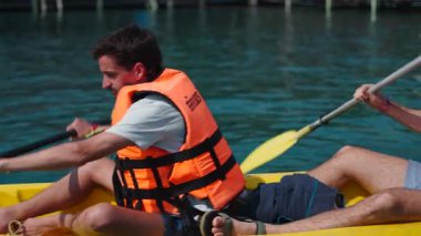 Kristal berrak sularda kayak macerasının keyfini çıkaran iki arkadaş - 4K Yatay