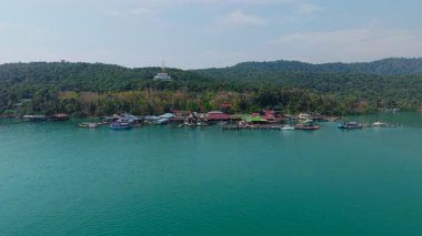 Loh Chang Adası deniz suyunda evleri ve tekneleri olan insansız hava aracı manzaralı - 4K Yatay