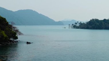 Sakin ve sakin bir denizde, küçük tropikal adaların üzerinde uçan dron - 4K Yatay