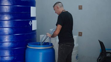 Depolama tesislerindeki boruları kullanarak tanklar arasındaki su akışını yöneten teknisyen.