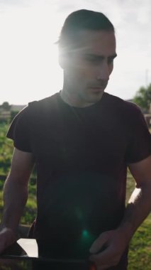 Kentin meyve bahçesi bahçesinde yürürken dijital verileri inceleyen kendinden emin çiftçi