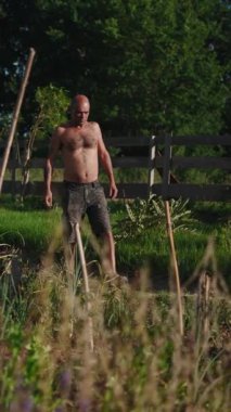 Kendine güvenen çiftçi, meyve bahçesinde geziniyor.