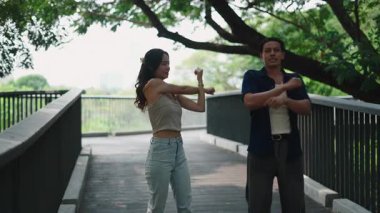 Çift esniyor, egzersizden önce ısınıyor, şehir köprüsünde yürüyor.