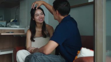 Romantik çift modern dairelerinde rahat bir kanepede birlikte vakit geçiriyorlar.