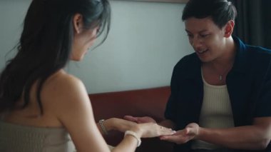 Kanepede yan yana otururken el çırpma oyunu oynayan oyuncu çift.