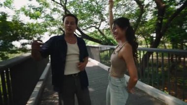 Gülen ortaklar ahşap köprü üzerinde yakın dans ediyorlar.