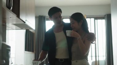 Sevgili eşler arasında sabah samimiyeti, kahveyi yudumlamak ve mutfak tezgahının yanında hassas anları paylaşmak.